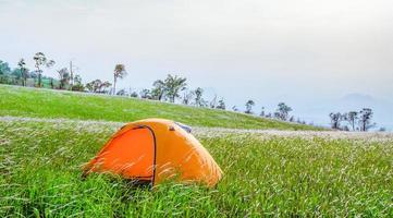 tienda de campaña turística en la colina paisaje de montaña pradera de hierba verde en la colina pendiente foto