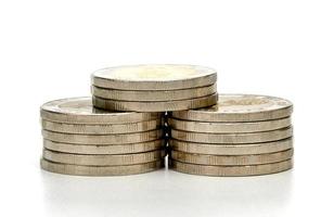 Primer plano pilas de monedas de plata aislado sobre fondo blanco. foto