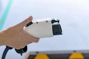 hand holding plug for charging battery of an electric car photo