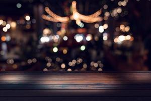 top desk with blur restaurant background,Wooden table and blurred bokeh of night street background photo