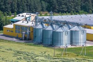 aerial view on agro silos granary elevator on agro-processing manufacturing plant for processing drying cleaning and storage of agricultural products, flour, cereals and grain. photo