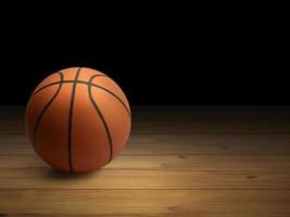pelota de baloncesto en el parquet con fondo negro foto