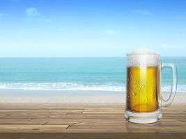 cerveza fría en el escritorio y fondo de la playa de verano foto