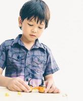 Vintage style of Asian lovely boy is playing Halloween clay happily photo