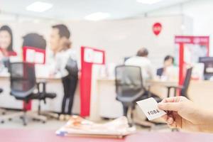 Man is holding queue card while waiting in the modern reception area photo