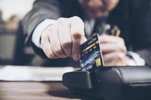 Merchant man's hand using credit card machine photo