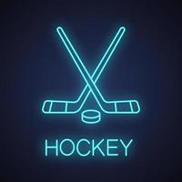 Crossed hockey sticks with puck neon light icon. Ice hockey equipment. Glowing sign. Vector isolated illustration