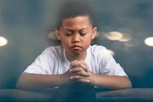 Boy praying to God at home photo