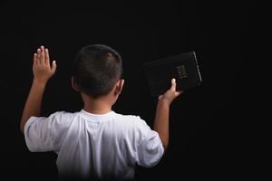 Boy praying to God at home photo