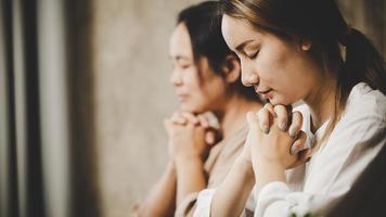 Two women praying worship believe photo
