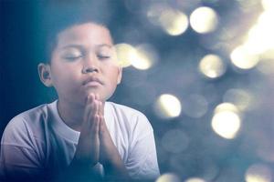 Boy praying to God at home photo