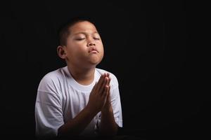 Boy praying to God at home photo