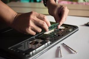 el ingeniero repara la computadora portátil y la placa base. instala el equipo foto