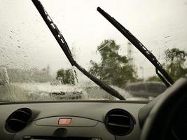 Windshield wipers from inside of car, season rain. traffic jam. photo