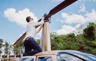 Male mechanic or pilot examining helicopter. Pre flight inspection at the helipad photo