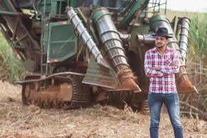 Rural businessman checking work. Sugarcane harvester machine. Farmer. photo