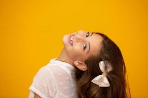 Portrait of a happy smiling child girl in yellow background. photo