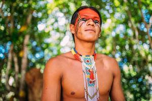 Indian from the Pataxo tribe smiling. Brazilian Indian from southern Bahia with necklace and traditional facial paintings looking to the left photo