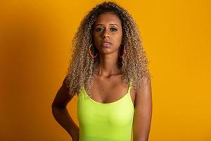 Attractive curly hair girl in a bright green bikini, hat, emotionally opened mouth on a bright yellow background with a perfect body. Isolated. Studio shot. photo