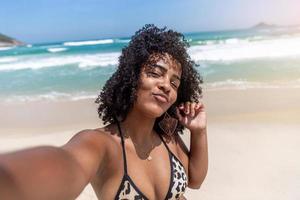 Black afro young cute girl, curly hair, bikini, beach. Afro American summer vacation holiday. photo