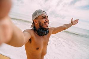 Friendly young Latin American man inviting to come to Brazil, confident and smiling making a gesture with his hand, being positive and friendly photo