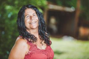 Portrait of smiling beautiful middle age. mature. older female farmer. Woman at farm in summer day. Gardening activity. Brazilian woman. photo