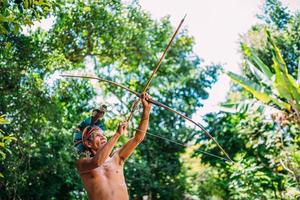 Indian from the Pataxo tribe, with a feather headdress and bow and arrow. Elderly Brazilian Indian photo