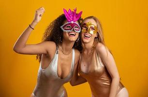 hermosas mujeres vestidas para la noche de carnaval. mujeres sonrientes listas para disfrutar del carnaval con una máscara colorida. foto