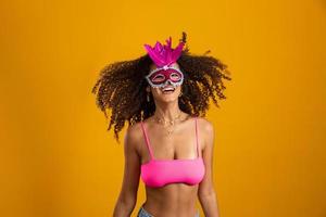 hermosa mujer vestida para la noche de carnaval. mujer sonriente lista para disfrutar del carnaval con una máscara colorida. foto