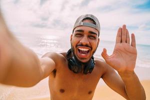 Friendly young Latin American man inviting to come to Brazil, confident and smiling making a gesture with his hand, being positive and friendly photo