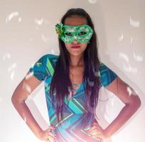 happy young woman with mask and confetti at carnaval party. Brazilian Carnival photo