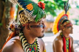 jefe de la tribu pataxo. indio brasileño con tocado de plumas, collar y pinturas faciales tradicionales mirando a la derecha