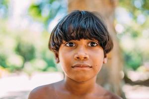 joven indio de la tribu pataxo del sur de bahia. niño indio mirando a la cámara. centrarse en la cara foto