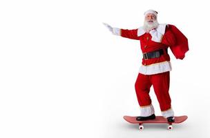 Santa riding a skateboard or longboard and holding a bag full of presents on white background. photo