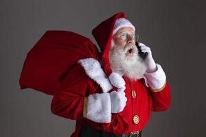 Santa Claus using a smartphone. Surprised. photo