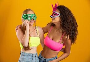 Beautiful women dressed for carnival night. Smiling women ready to enjoy the carnival with a colorful mask. Friends. Brazilian Carnival. photo