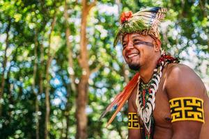 jefe de la tribu pataxo sonriendo. indio brasileño con tocado de plumas y collar mirando a la izquierda