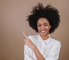 A young Latin girl points to the sides. Advertisement and presentation concept. Pastel background. photo