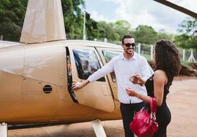 Successful smart stylish young latin woman near helicopter. Luxury lifestyle concept photo