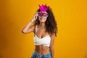 Beautiful woman dressed for carnival night. Smiling woman ready to enjoy the carnival with a colorful mask. photo