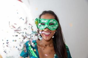 happy young woman with mask and confetti at carnaval party. Brazilian Carnival photo