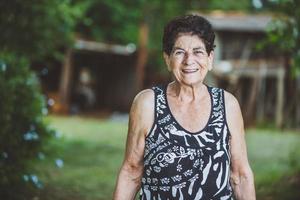 retrato de una hermosa granjera mayor sonriente. mujer en la granja en día de verano. actividad de jardinería. anciana brasileña. foto