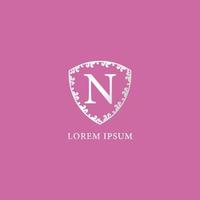 N Letter Intial logo design template. Luxury silver decorative floral shield illustration. Isolated on pink color background. Suitable for Insurance, fashion and beauty product. vector