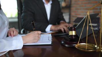 Business and lawyers discussing contract papers with brass scale on desk in office. Law, legal services, advice,  justice and law video