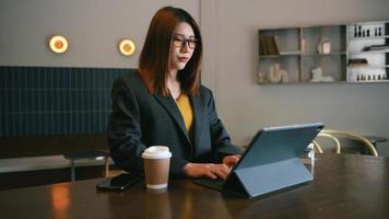 processo di lavoro in un ufficio moderno. giovane donna account manager che lavora al tavolo con un nuovo progetto di business. digitando la tastiera, utilizzando un laptop contemporaneo. video