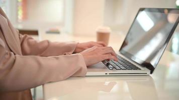 mãos de mulher usando laptop e tablet digital em home office video