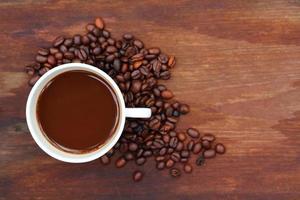 Coffee cup with Coffee beans on wood background photo