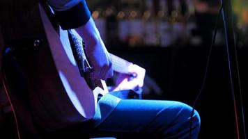 Musician in night club - guitarist plays rock acoustic guitar