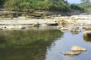 Rocks on the Riverside with Reflection in The Water photo