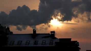 Winter cold sunset above city buildings roof, time-lapse, telephoto video